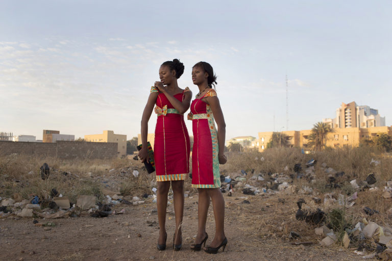 Deux jumelles en tenue de fête photographiées dans un terrain vague, Ouagadougou, Burkina Faso, 2016.