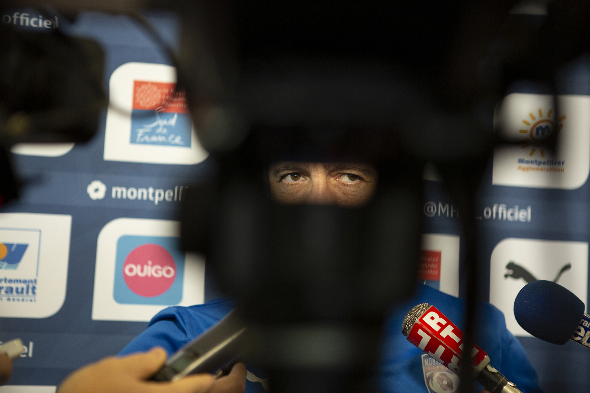 Gros plan du visage de l'entraineur Fabien Galthié entouré de micros pendant un interview-presse après une défaite à domicile, décembre 2014.